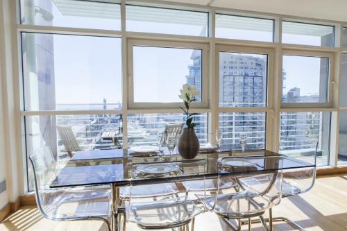 a dining room with a glass table and chairs at RENT4REST LISBON PARQUE DAS NAÇÕES 17Th FLOOR RIVER VIEW in Lisbon