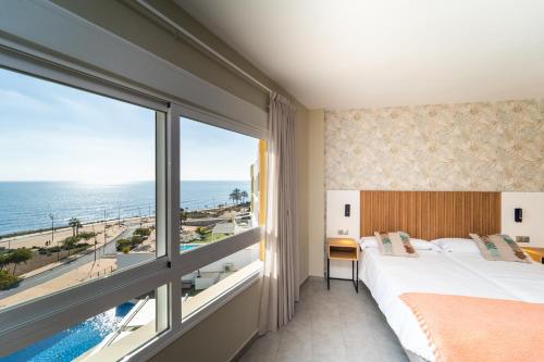 um quarto com uma cama e uma grande janela em Hotel Vistamar Wellness by DLV em Villajoyosa
