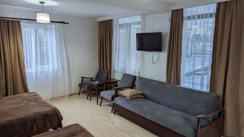 a hotel room with a couch and a table and a television at Park Avenue Kobuleti in K'obulet'i