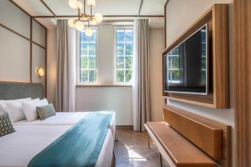 a hotel room with a bed and a flat screen tv at Canfranc Estación, a Royal Hideaway Hotel - Gran Lujo in Canfranc-Estación