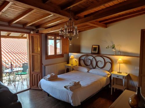 Un dormitorio con una cama grande y una lámpara de araña. en Alojamientos La Herrera en San Esteban de la Sierra
