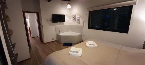 Habitación con cama, aseo y TV. en Playa Bonita Mar Azul en Balneario Mar Azul