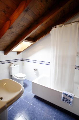 a bathroom with a tub and a toilet and a sink at Puente Romano in Cangas de Onís
