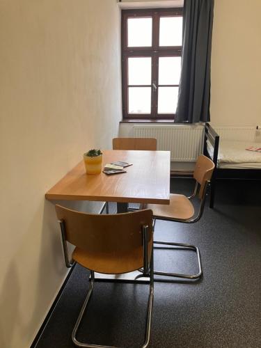 mesa y sillas en una habitación con cama en Hostel Eleven en Brno
