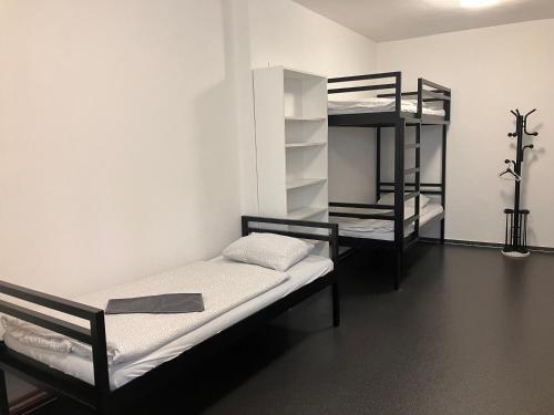 a room with two bunk beds and a shelf at Hostel Eleven in Brno