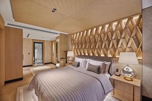 Vakko Hotel and Residence في إسطنبول: غرفة نوم بسرير كبير وبجدار خشبي