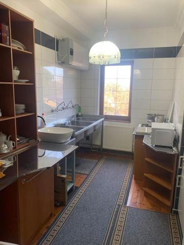 a large kitchen with a sink and a window at Manor House on the Danube Bend in Tahitótfalu