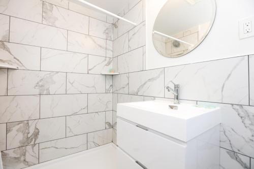 a white bathroom with a sink and a mirror at The Heritage Inn in Cape May