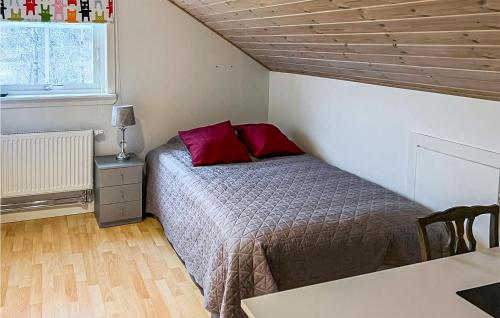 a bedroom with a bed with red pillows on it at Awesome Home In Ronneby With Kitchen in Ronneby