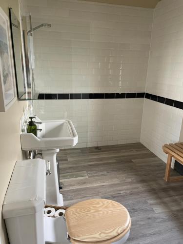 a bathroom with a sink and a toilet at Pool House, farm stay in Brackley