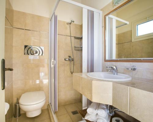 uma casa de banho com um WC, um lavatório e um chuveiro em Irini Apartment em Lassi