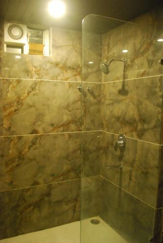 a bathroom with a shower with a glass door at Hotel New Sunder in Indore