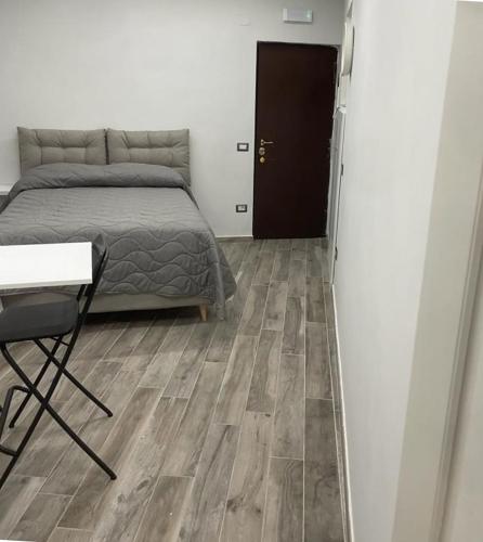 1 dormitorio con 1 cama, 1 mesa y 1 silla en La Casina di Michele a Napoli, en Nápoles