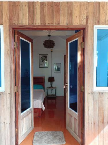 a bedroom with an open door with a bed and windows at Treasure Beach Resort in Carles