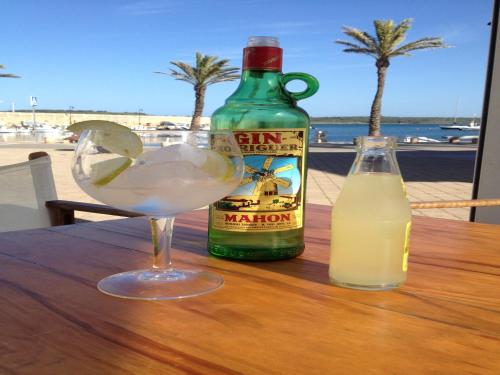a drink and a bottle of milk on a table at Hostal La Palma in Fornells