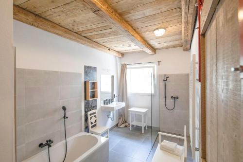y baño con bañera y lavamanos. en das ZINIELS, en Sankt Andrä bei Frauenkirchen