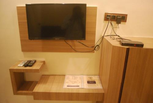 a room with a television on a wall with a book at Hotel New Sunder in Indore
