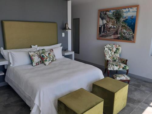 a bedroom with a large white bed with a chair at 65onCliff in Gansbaai