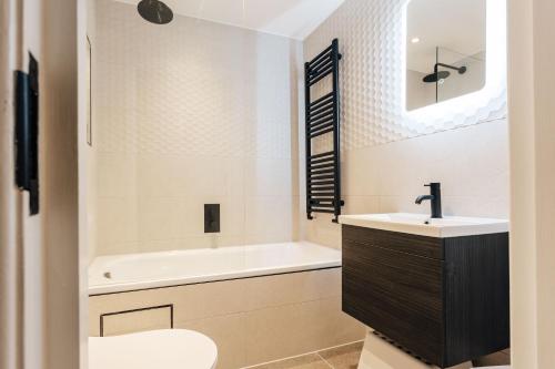 a bathroom with a sink and a tub and a toilet at Modern Peaceful Flat in Town in Bournemouth