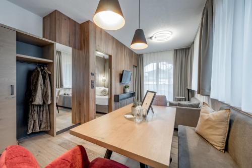 a living room with a table and a bedroom at Appartements Perberschlager in Oetz