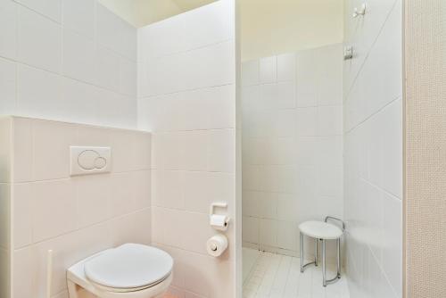 a white bathroom with a toilet and a shower at Elckerlyck Inn Hotel in Rollegem