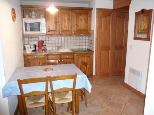 une cuisine avec une table et des chaises dans une pièce dans l'établissement Charmant 3 pièces avec balcon et garage, proche télécabine à Méribel - FR-1-411-640, à Les Allues