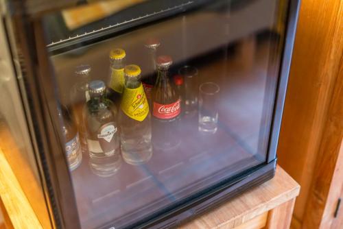 a glass refrigerator filled with bottles of alcohol at Elckerlyck Inn Hotel in Rollegem