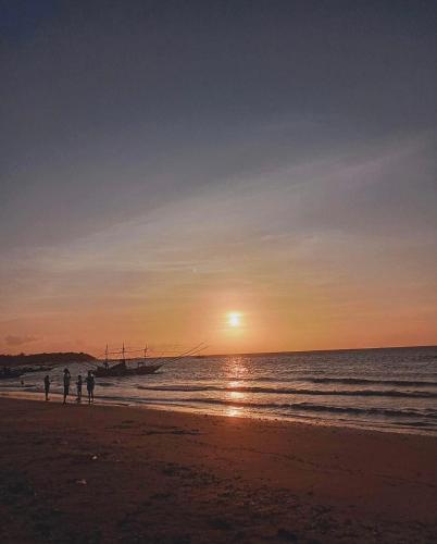 two people standing on the beach at sunset at Treasure Beach Resort in Carles