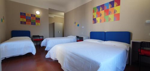 2 camas en una habitación con sábanas blancas en Hotel Genesi, en Florencia