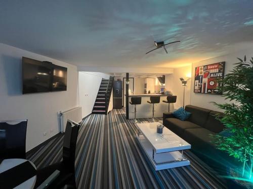 una sala de estar con un sofá y una mesa en La P'tite Maison et votre terrasse privé !, en Joinville