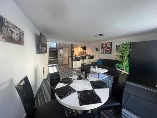 sala de estar con mesa blanca y sillas negras en La P'tite Maison et votre terrasse privé !, en Joinville