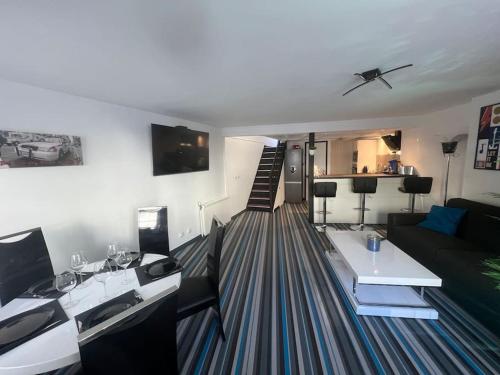 un salon avec un canapé et une chambre avec un escalier dans l'établissement La P'tite Maison et votre terrasse privé !, à Joinville