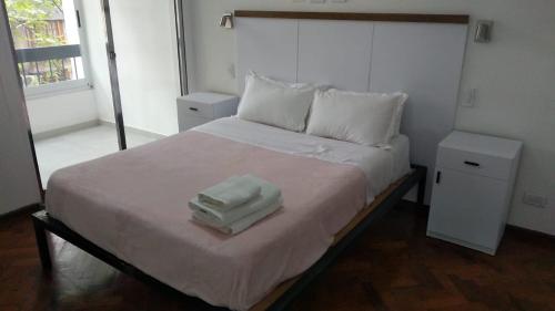 1 dormitorio con 1 cama con 2 toallas en Amplio departamento Balcon pleno centro Peatonal en Mendoza