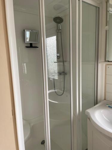a shower with a glass door in a bathroom at Immaculate 2-Bed Static Caravan at Monrieth in Newton Stewart