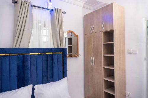 a bedroom with a bed with a blue curtain at Awesome 1-Bed-Apt With 24hrs Power & Fast WiFi in Lagos