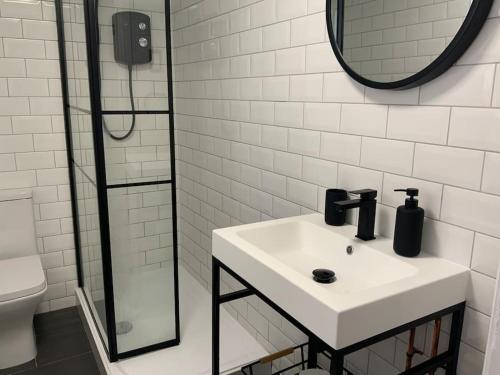 a white bathroom with a sink and a mirror at Centrally located to the city of Lincoln (Egon) in Lincolnshire