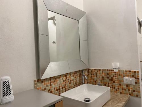 a bathroom with a white sink and a mirror at Da Rosina in Palermo