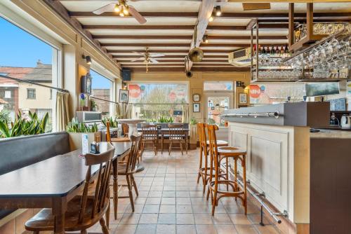 a restaurant with a bar and tables and chairs at Elckerlyck Inn Hotel in Rollegem
