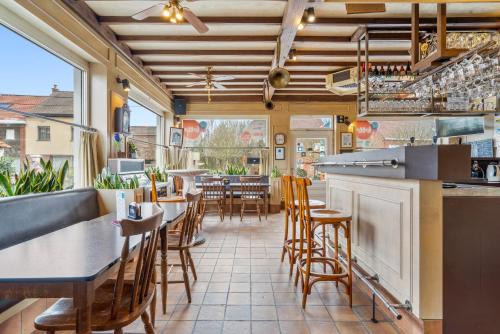 a restaurant with a bar and tables and chairs at Elckerlyck Inn Hotel in Rollegem