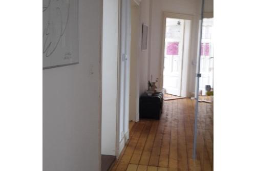 un corridoio con pareti bianche e pavimento in legno di Private Room ad Hannover