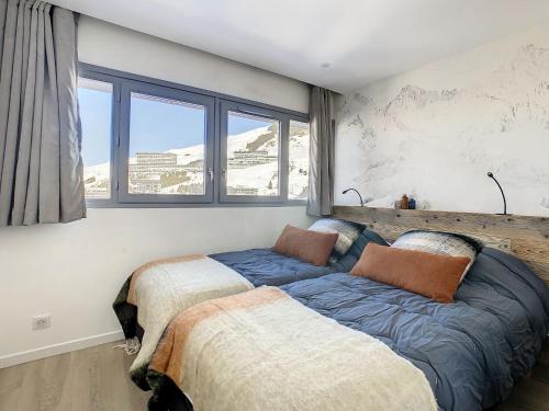 a bedroom with two beds and a large window at Apartment Burons 709-718 by Interhome in Les Menuires