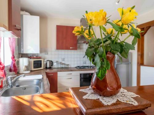 a vase filled with yellow flowers sitting on a table at Apartment Kafartenea by Interhome in Urrugne