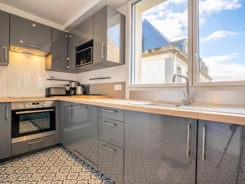 une cuisine blanche avec un évier et une fenêtre dans l'établissement Apartment Vue Solidor-2 by Interhome, à Saint-Malo