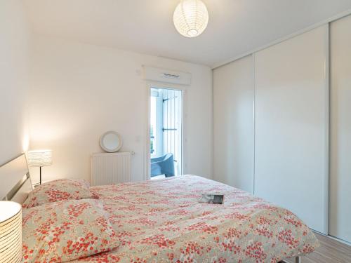 a bedroom with a bed with a flowered comforter at Apartment Xabadenia-4 by Interhome in Bidart