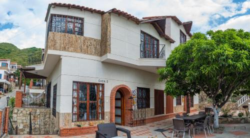 聖瑪爾塔的住宿－Villa Roca, Rodadero，前面设有桌椅的白色房子