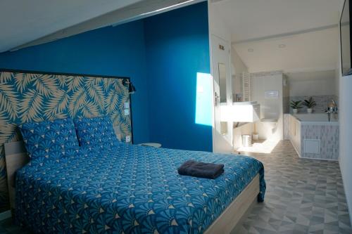 una camera blu con un letto e una parete blu di Appart Cosy 4 personnes avec terrasse a La Roche-sur-Yon