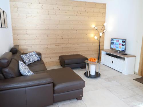 sala de estar con sofá marrón y TV en Apartment Chalet Molignon by Interhome, en Haudères