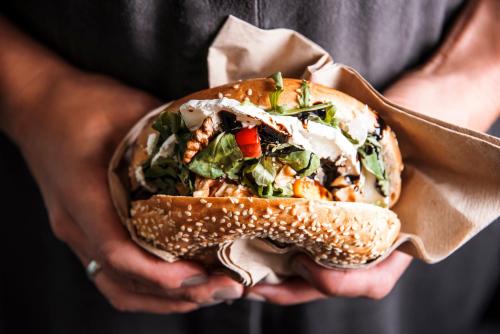 a person holding a sandwich in their hands at Vignette Collection Yours Truly DC by IHG in Washington
