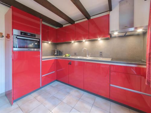 eine Küche mit roten Schränken und einem Waschbecken in der Unterkunft Holiday Home Zeepark Zeepolder-7 by Interhome in De Haan