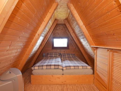 a bed in the attic of a wooden cabin at Chalet Alwin by Interhome in Heidersbach